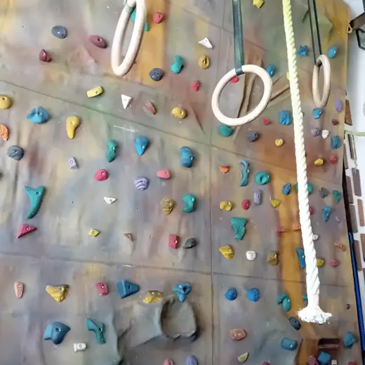 Pared de escalada con anillas y cuerda colgadas